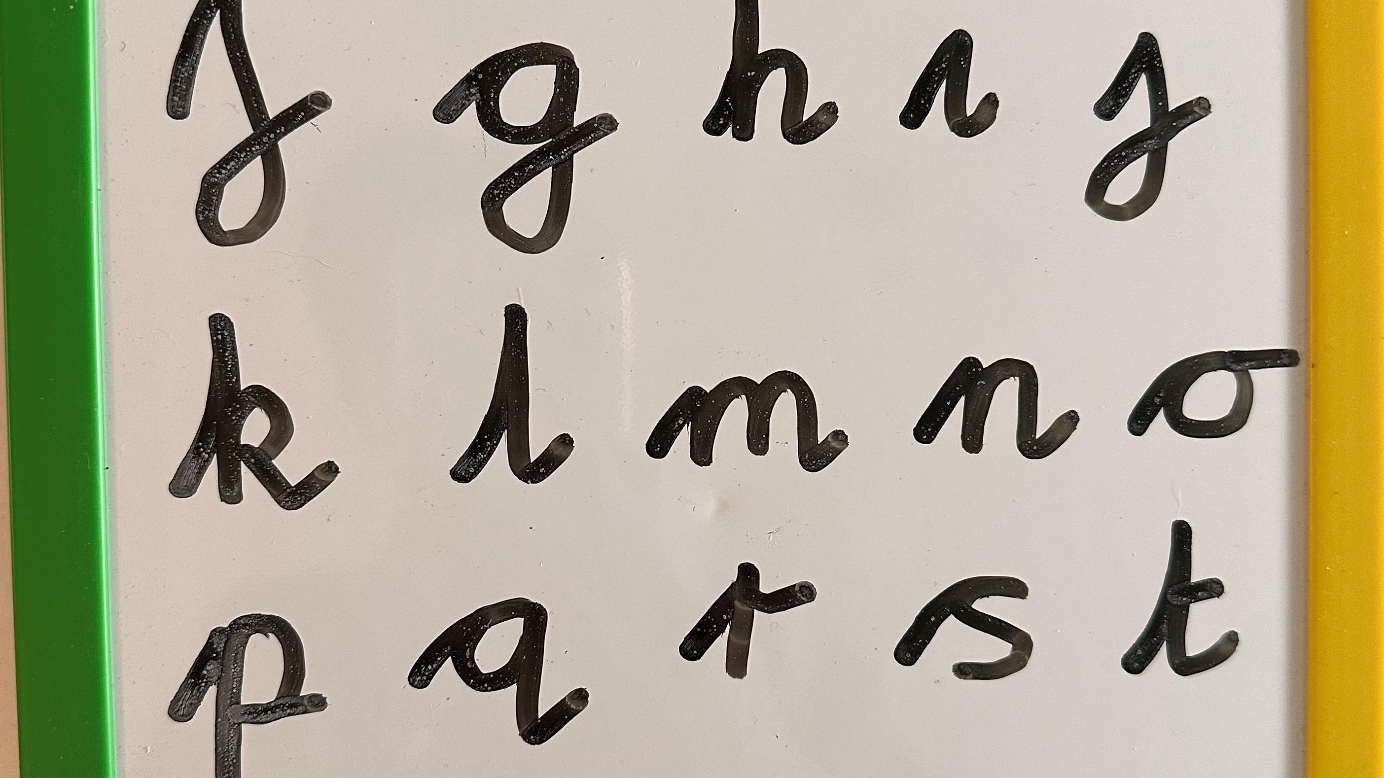 Alphabet written in a cursive script on a wipeboard 