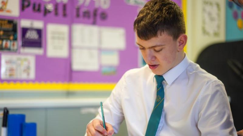 student writing at the desk